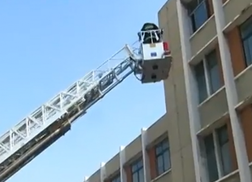 消防隊員啟動登高平臺消防車，將女子成功救下。（視頻截圖）