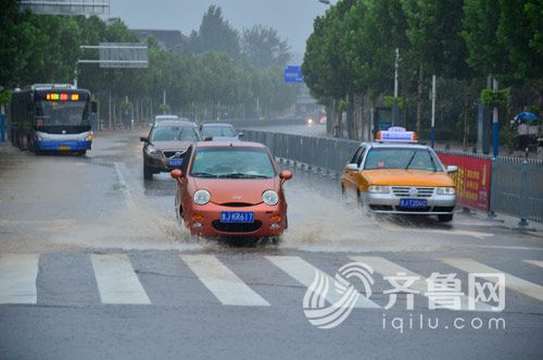 20日上午9时左右，泰安市区雨中“跋涉”的车辆 实习生 徐深 摄