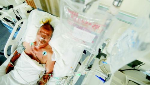 在菏澤市中醫醫院ICU病房裏，今年67歲的環衛工耿大爺因中暑躺在病床上。 本報記者 鄧興宇 攝