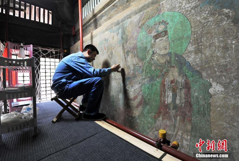 8月10日，位於河北正定的千年古寺——隆興寺，來自敦煌研究院的工作人員，正在摩尼殿內仔細的進行 
壁畫修復 
工作。據了解，由於長期的自然侵害，壁畫保存狀況較差，他們將花費兩年的時間，對現存近400平方米的 
明代 
壁畫進行修復。圖為 
壁畫修復 
現場。 中新社記者 翟羽佳 攝