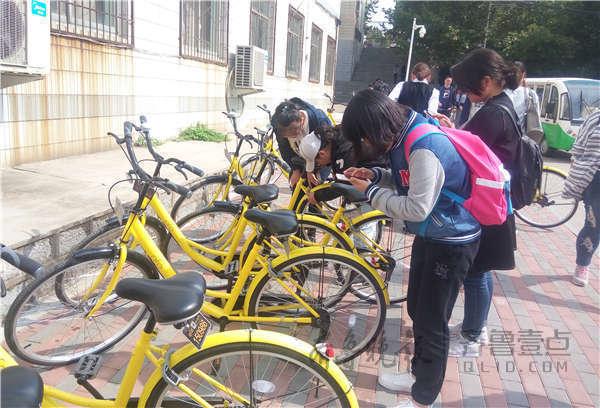 學生們用手機掃碼準備騎走小黃車。