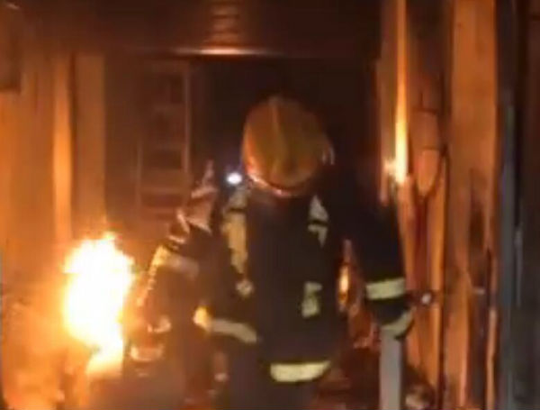 菏泽一饭店突然起火 消防员徒手拖出着火煤气罐（图）