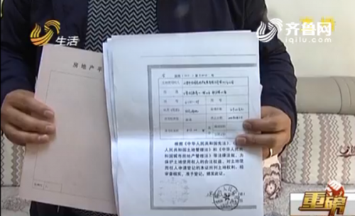業主崔先生出示了房子的房産證和一份土地證的複印件 （視頻截圖）.png