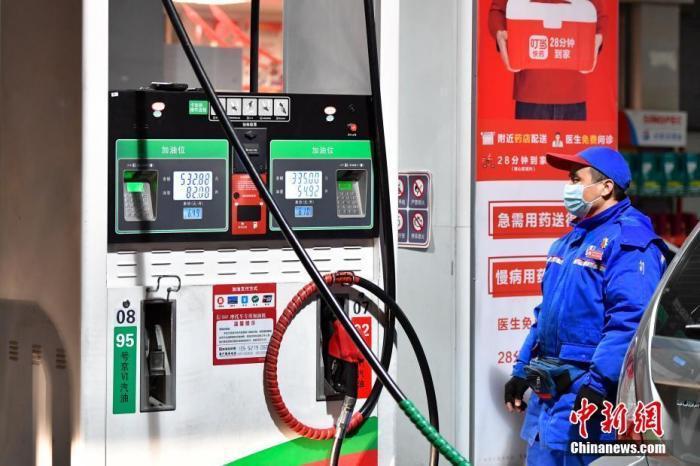 圖為工作人員在北京一處加油站為車輛加油。 <a target=